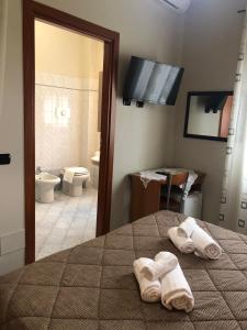 a bedroom with a bed with towels on it with a bathroom at Residence Oasi Di Monza in Monza