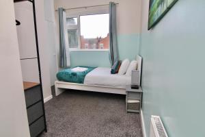 a small bedroom with a bed and a window at Mount Haven's Rest - Free Parking, Netflix & Private Back Garden in Coventry +12 photos