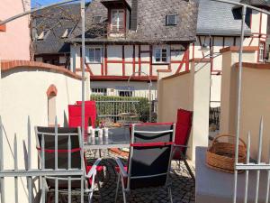 um pátio com cadeiras e uma mesa em frente a uma casa em Spitzhaus Wolf em Traben-Trarbach