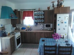 a kitchen with a table and a white refrigerator at Traditional House Marivilla in Mastihari