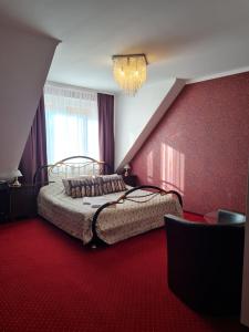 1 dormitorio con 1 cama y alfombra roja en "Arkadia" en Ostrołęka