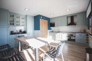 a kitchen with blue cabinets and a table and chairs at Casa Rural Sierra Oeste in Madrid