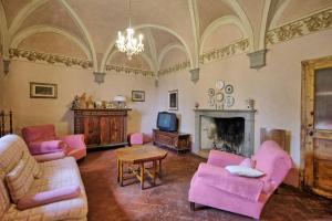 a living room with pink furniture and a fireplace at Villa Guadagni Cappelli in Arezzo