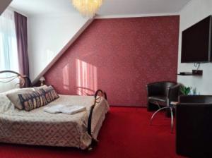 sypialnia z łóżkiem i czerwoną ścianą w obiekcie "Arkadia" w mieście Ostrołęka