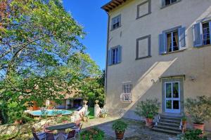 an exterior view of a building with a table and chairs at Villa Guadagni Cappelli in Arezzo