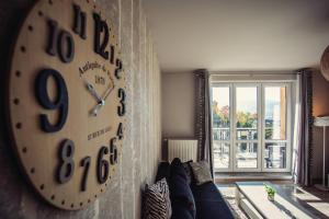 a clock hanging on a wall in a living room at Apartament VIEW Wisla in Wisła