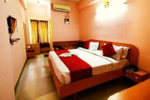 una camera da letto con un grande letto con cuscini rossi di Hotel Kirthikaa Palace Salem a Salem