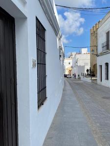 um edifício branco com um portão ao lado de uma rua em APARTAMENTO ATALAYA CORREDERA VEJER em Vejer de la Frontera