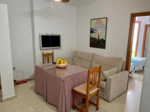ein Wohnzimmer mit einem Tisch und einem Sofa in der Unterkunft APARTAMENTO ATALAYA CORREDERA VEJER in Vejer de la Frontera
