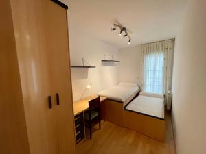 een kleine slaapkamer met een bed en een bureau bij MIGUEL SERVET in Zaragoza