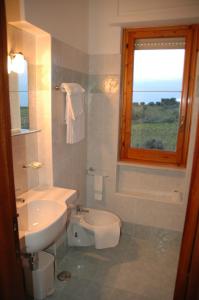 フランカヴィッラ・アル・マーレにあるHotel Ristorante Vernaのバスルーム(洗面台、トイレ付)、窓が備わります。