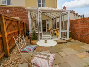 a patio with a table and chairs and a pavilion at 6 Erwr Brenhinoedd in Ammanford