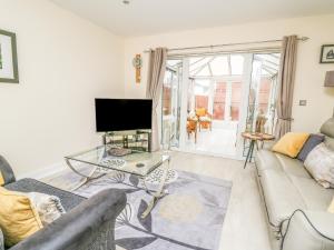 a living room with a couch and a tv at 6 Erwr Brenhinoedd in Ammanford