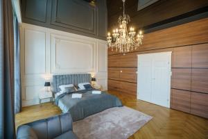 a bedroom with a bed and a chandelier at Prestige Apartment Rynek Kielce in Kielce