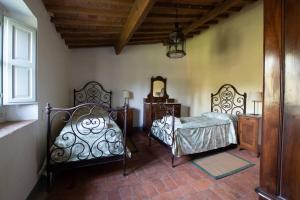 a bedroom with two beds and a mirror at Stone House 15th Century in Vicchio