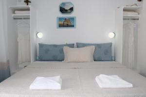 a white bed with two white towels on it at Aphrodite of Milos in Adamas