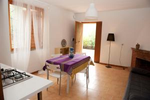 a kitchen with a table with a purple table cloth on it at Elena Residence in Torchiara +20 photos