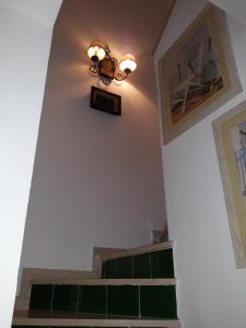 a stairway with a light fixture and green tiles at Olhando um Campo de Golf in Islantilla