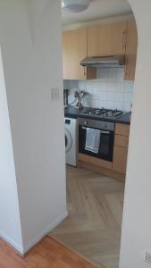 a kitchen with a stove and a microwave at Mornington Place in London