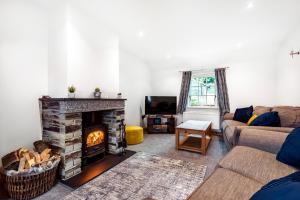a living room with a fireplace and a couch at Eveley Cottage in Boscastle