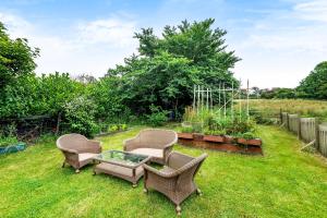drie stoelen en een salontafel in de tuin bij Eveley Cottage in Boscastle +2 foto's