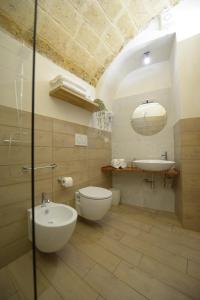 bagno con servizi igienici, lavandino e specchio di Castrum Casa Vacanza a Mesagne