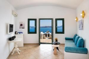 a living room with a blue couch and a view of the ocean at Epic View Suites in Akrotiri