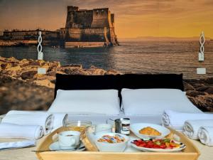 a table with a tray of food on a bed at DUOMO 152 NAPOLI in Naples