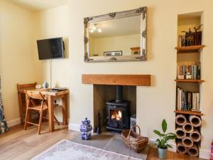 a living room with a fireplace and a mirror at Little Wenlock in Skipton
