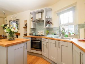 a kitchen with white cabinets and a counter top at Little Wenlock in Skipton