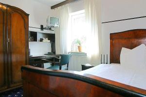 a bedroom with a bed and a desk with a computer at Runa´s Aparthotel in Hallbergmoos