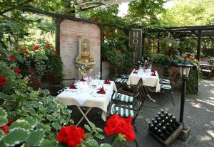 a group of tables and chairs with red flowers at Runa´s Appartment in Hallbergmoos