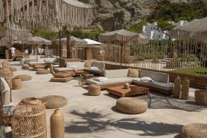 a seating area with couches and tables and umbrellas at Maya Beach Resort in Massa Lubrense