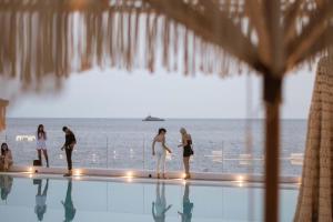 a group of people standing at the edge of a swimming pool at Maya Beach Resort in Massa Lubrense