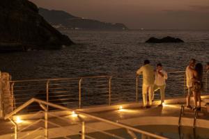 a group of people standing on the deck of a boat at Maya Beach Resort in Massa Lubrense