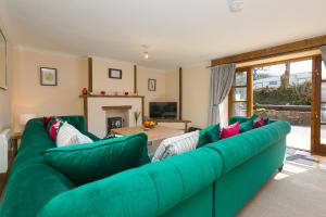 a living room with a green couch and a table at RiversideThe West Dry in St Austell