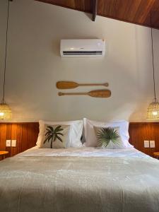 a bedroom with a bed with a air conditioner on the wall at Tropicália chalés boutique in Pipa