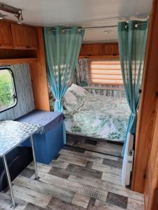 een uitzicht op een camper met een bed en gordijnen bij la Carabol Der in Voillecomte