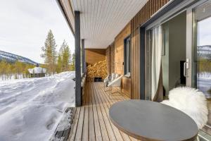 SuomutunturiにあるHoliday Apartments Suomu Chalet 14 A & Bの雪の中のデッキにテーブルが付いた部屋