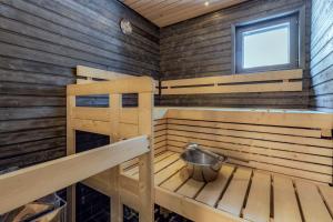 Cabaña de madera con bañera y ventana en Holiday Apartments Suomu Chalet 14 A & B en Suomutunturi