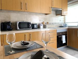 a kitchen with a table with two wine glasses at Discovery Tavira in Tavira