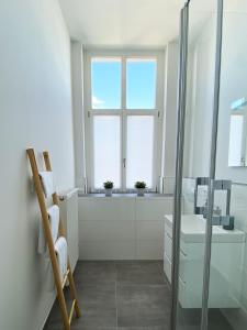 baño blanco con lavabo y ventana en Best Boarding House, en Hanau am Main