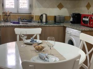 a kitchen with a table and chairs with wine glasses at Discovery Tavira in Tavira +42 photos