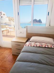 1 dormitorio con cama y vistas al océano en La Paloma, Chalet a pie de playa, en Águilas