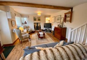 a living room with a couch and a tv at Turnpike Cottage in Tetbury