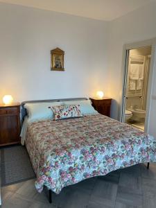 um quarto com uma cama grande e uma colcha floral em Casali appartamento em San Marino