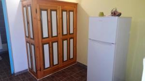 uma cozinha com um frigorífico branco e uma porta de madeira em Appartement de 2 chambres avec vue sur la mer jardin et wifi a Capesterre de Marie Galante em Capesterre