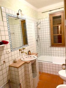 ein weiß gefliestes Bad mit einem Waschbecken und einer Badewanne in der Unterkunft 2 bedrooms appartement with shared pool furnished garden and wifi at Montecarlo in Montecarlo