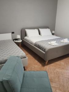 a bedroom with two beds and a chair in it at Lamezia Park Apartments in Lamezia Terme