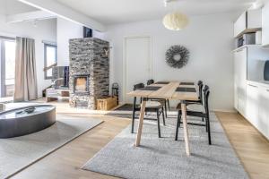 a kitchen and dining room with a table and a fireplace at Suomu Chalet - two bedroom and loft for 8 in Suomutunturi